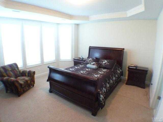 5208 Holly Ridge Farm Road Raleigh, NC 27616 - Photo 8 of 12 a bed sitting in a bedroom next to a window with a large mirror and a couch