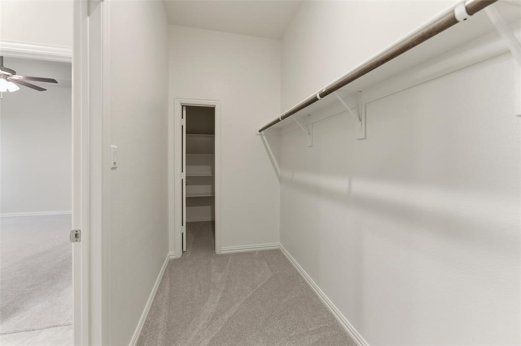 119 Hillview Trail Decatur, TX 76234 - Photo 7 of 30 Walk-in closet featuring carpet flooring, crisp white walls, and a built-in hanging rod with shelving