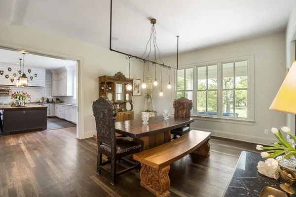 a dining room with furniture a chandelier and wooden floor
