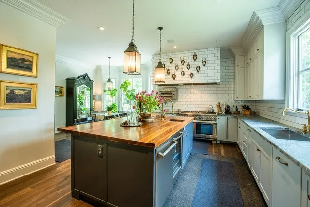 a kitchen with stainless steel appliances granite countertop a sink a stove and a wooden floors