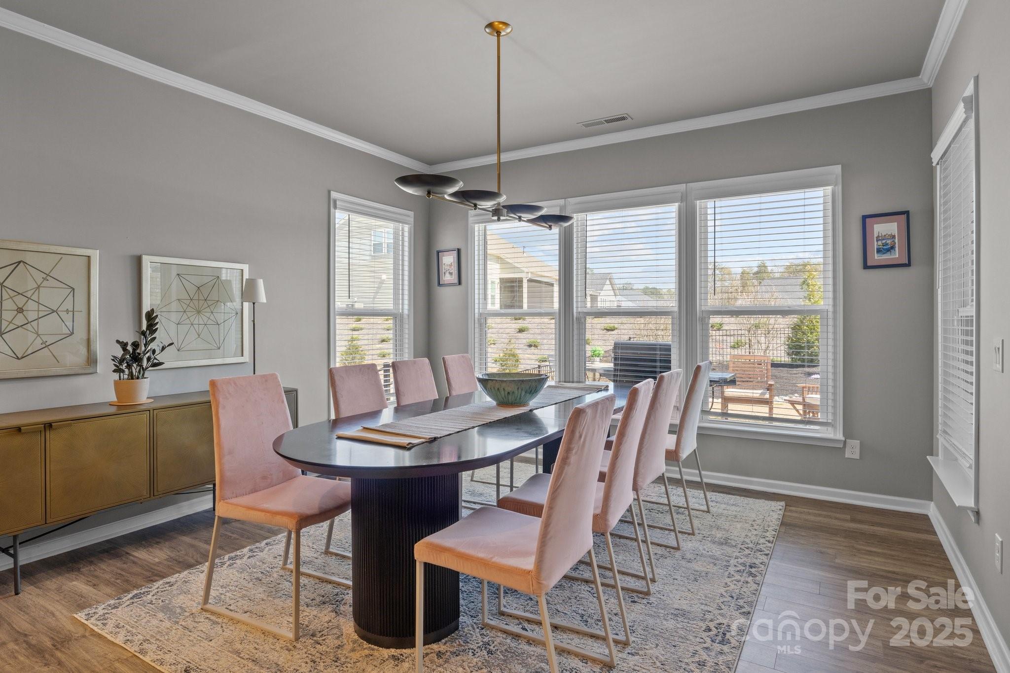 12709 Messenger Row Huntersville, NC 28078 - Photo 18 of 45 a dining room with furniture a chandelier and wooden floor