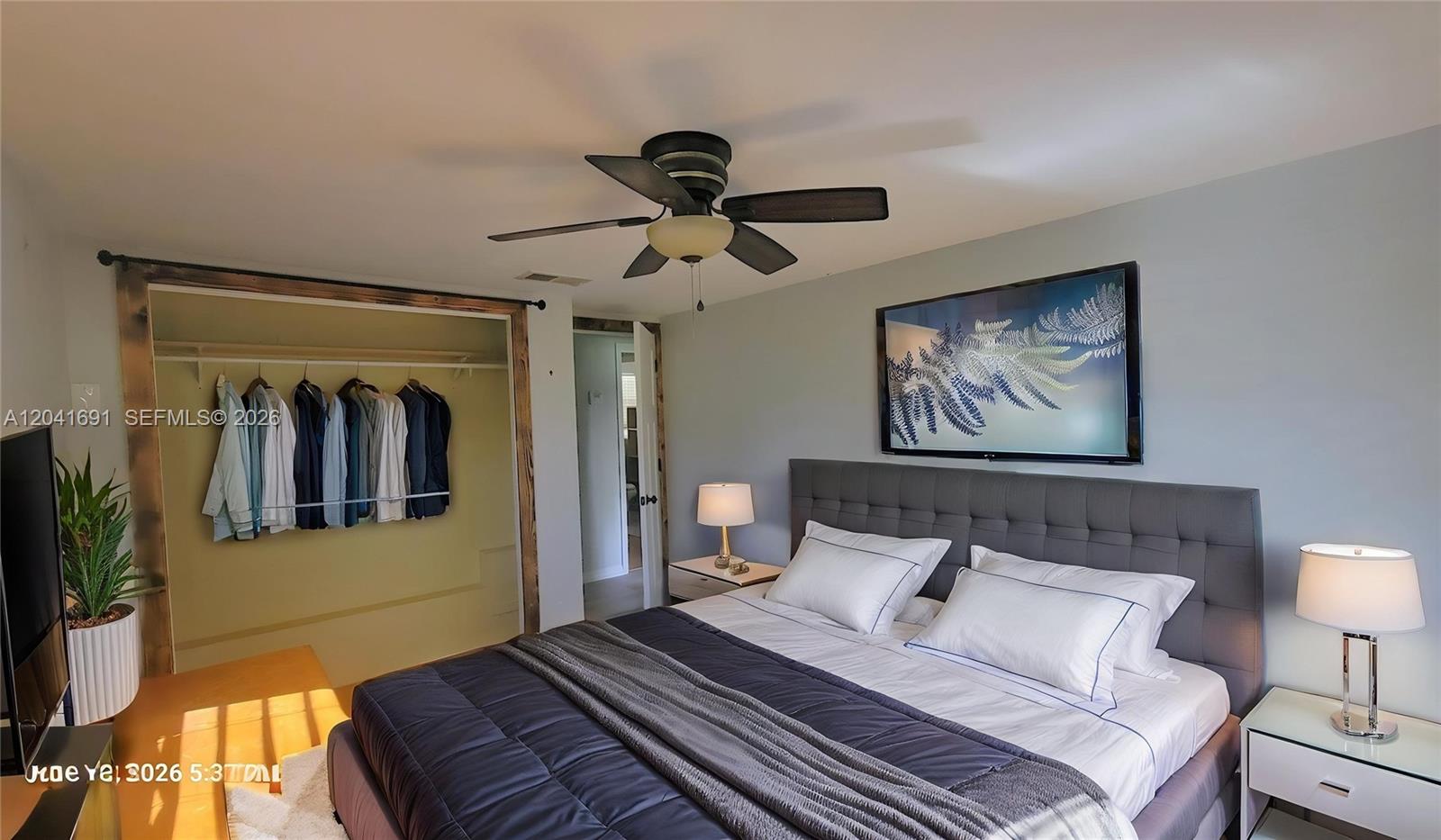 1270 Nobles Road LaBelle, FL 33935 - Photo 10 of 18 a bedroom with a large bed a painting on the wall and a lamp
