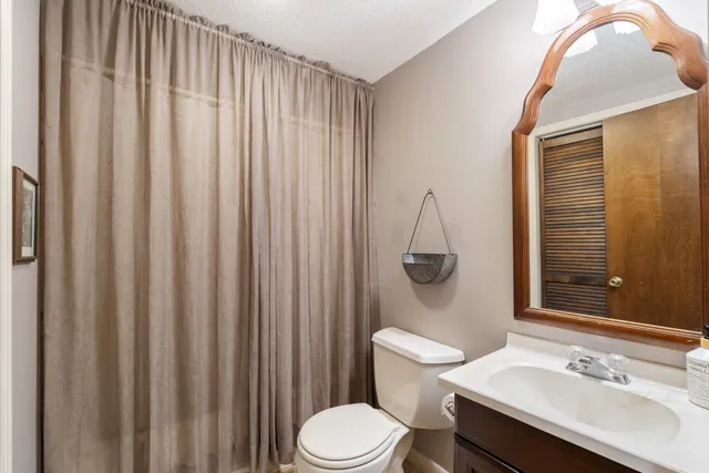 a view of a house with a yard and large trees