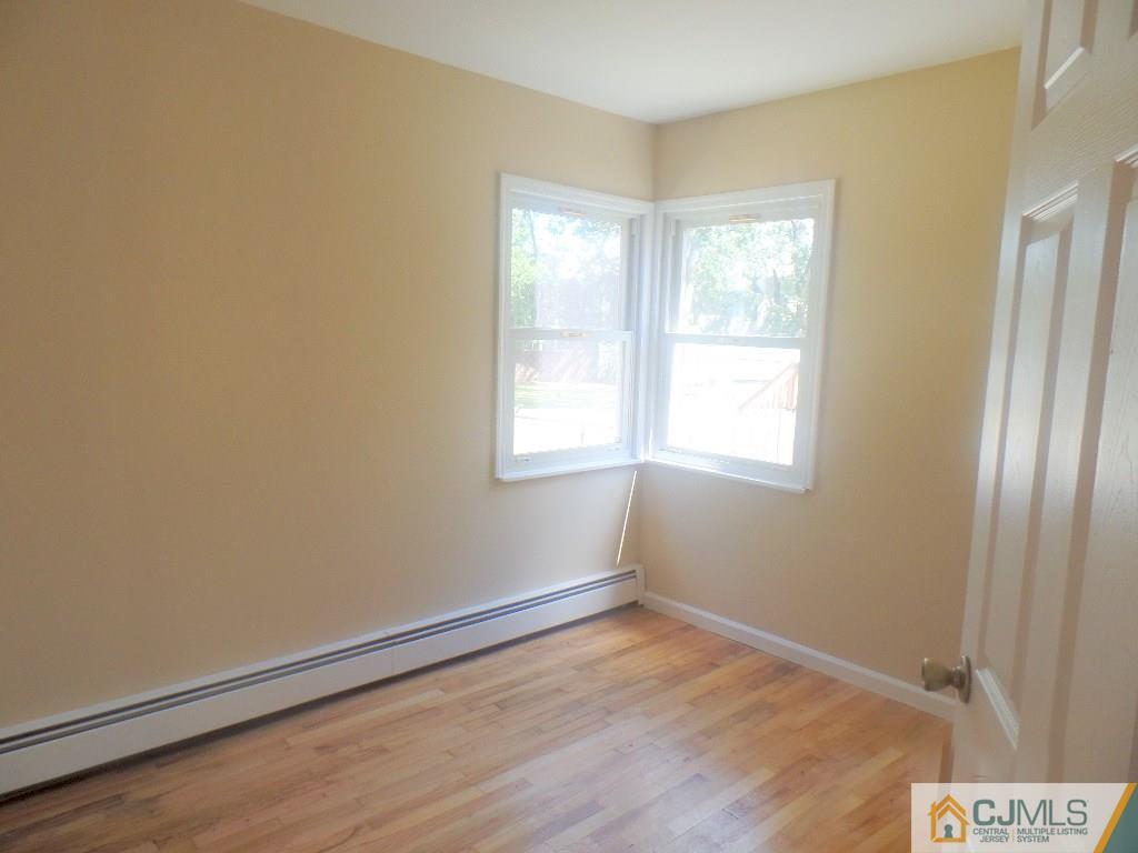 195 Midfield Road Colonia, NJ 07067 - Photo 9 of 21 a view of an empty room with wooden floor and a window