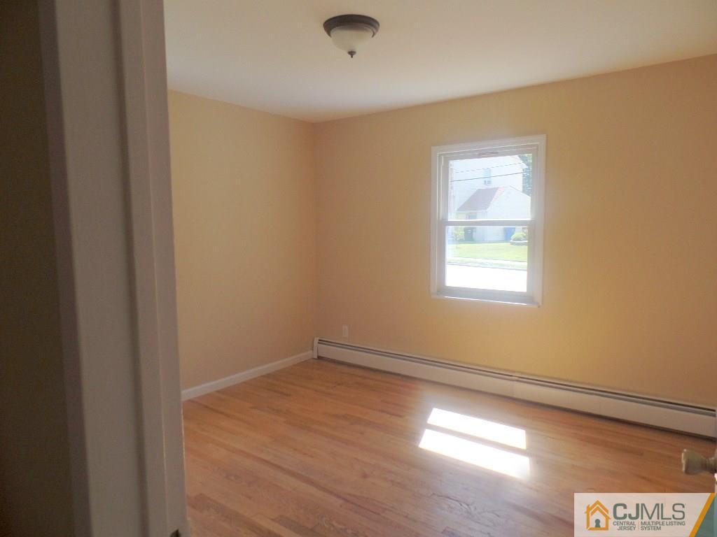 195 Midfield Road Colonia, NJ 07067 - Photo 10 of 21 an empty room with wooden floor and windows