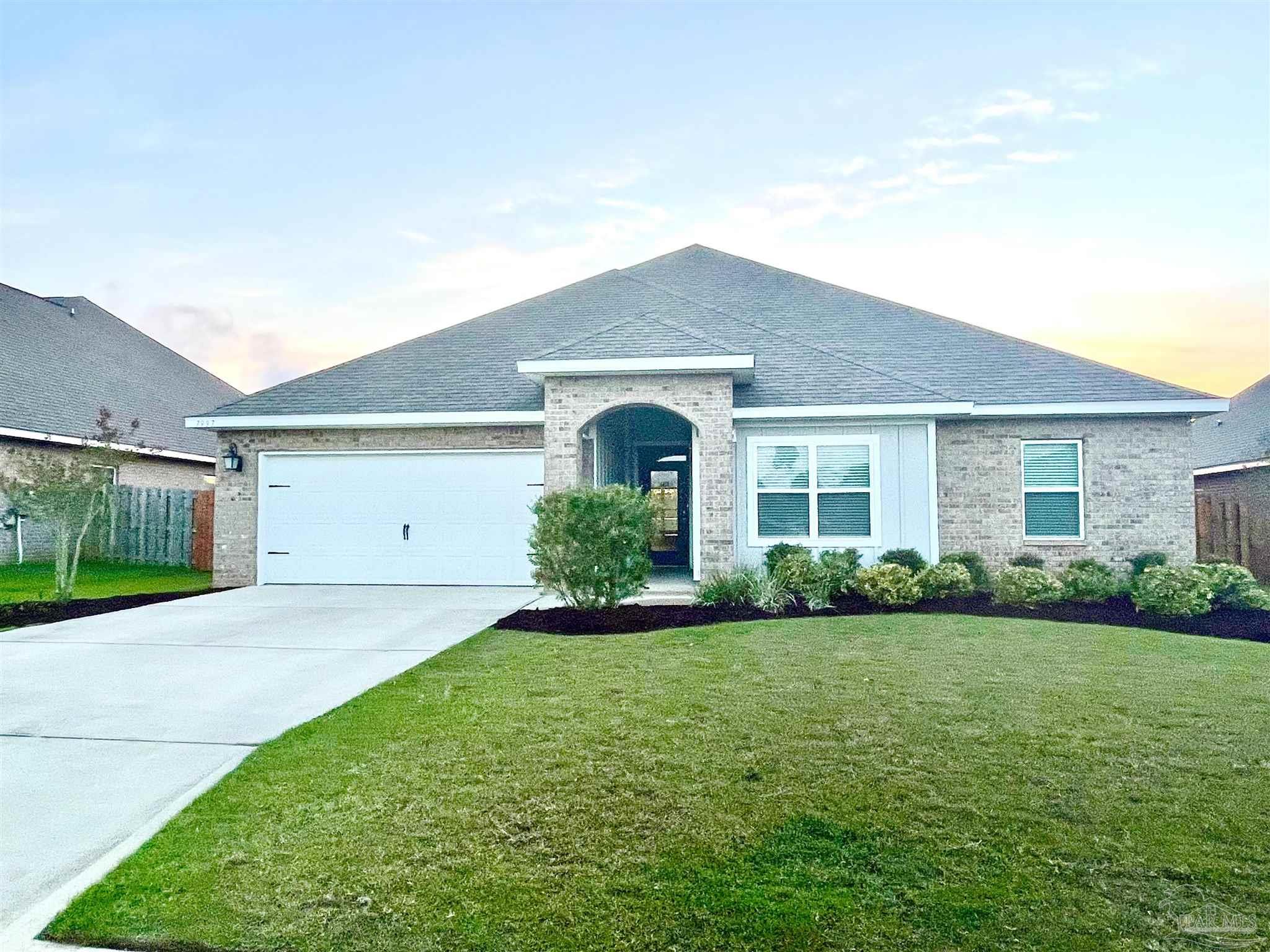 7997 Woodbrook Road Pensacola, FL 32526 - Photo 1 of 35 a front view of a house with a yard and garage