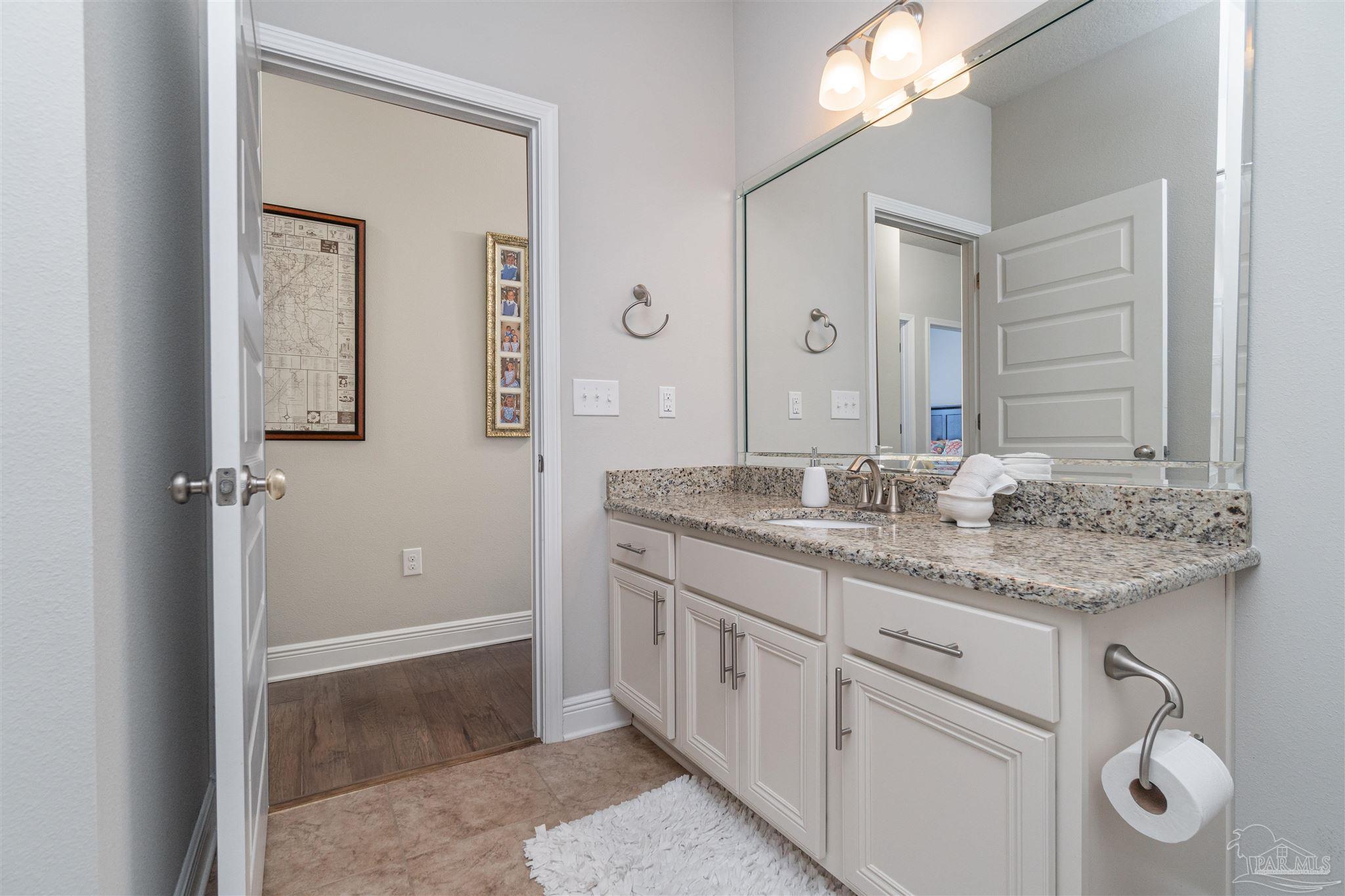 7997 Woodbrook Road Pensacola, FL 32526 - Photo 15 of 35 a bathroom with a granite countertop sink and a mirror