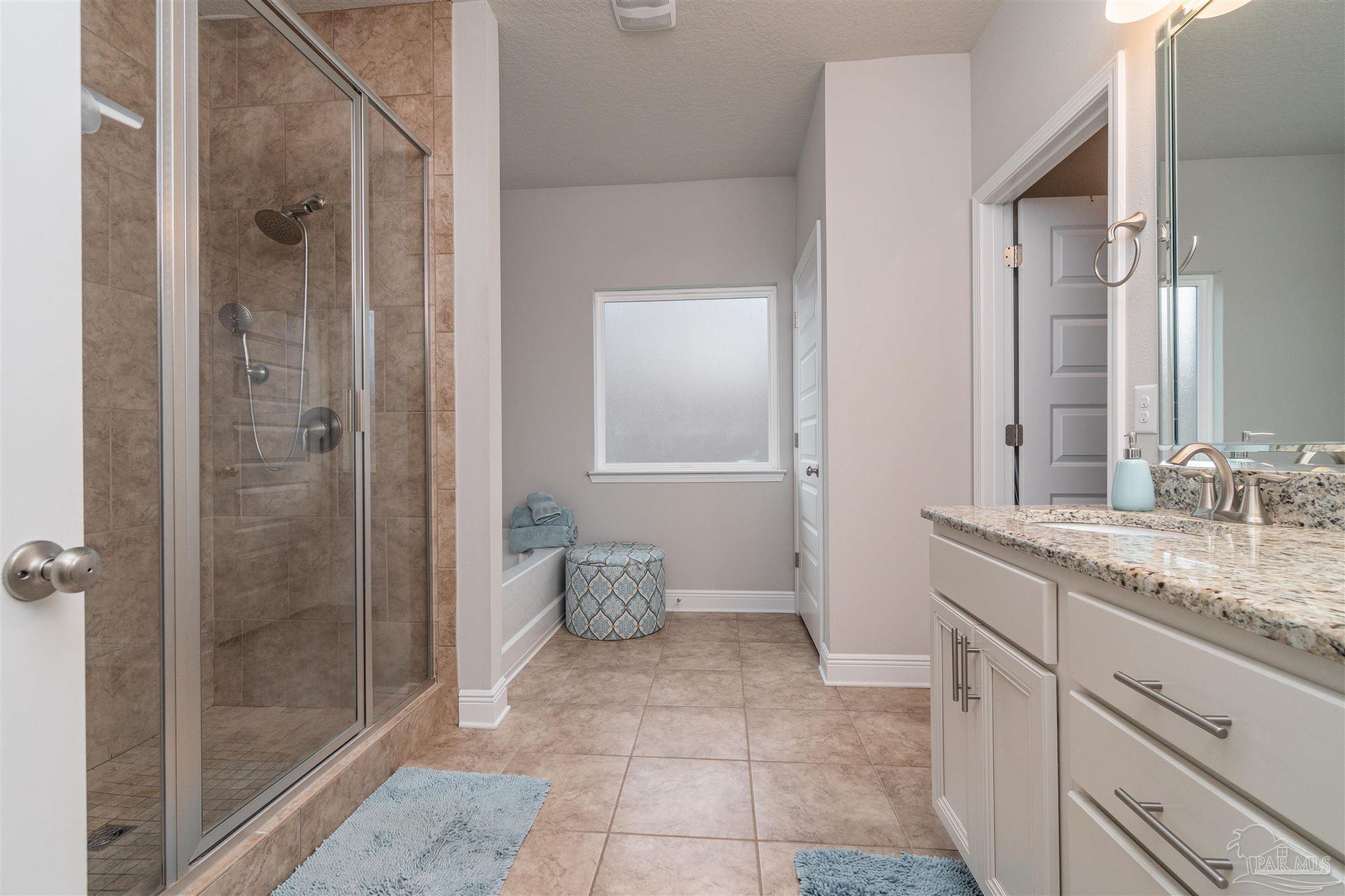 7997 Woodbrook Road Pensacola, FL 32526 - Photo 25 of 35 a bathroom with a granite countertop sink a mirror and a shower