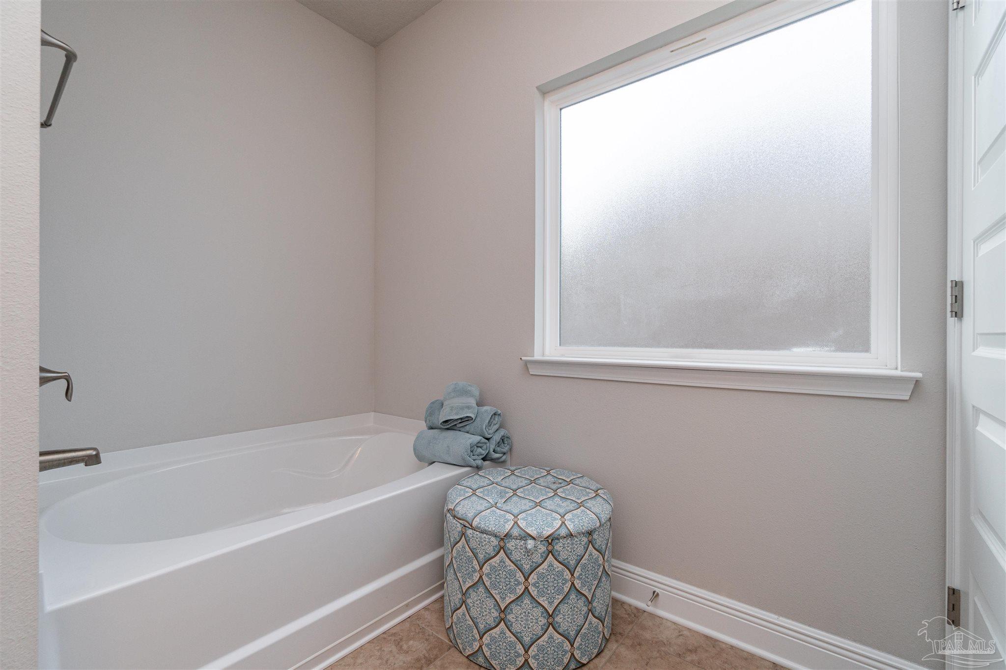 7997 Woodbrook Road Pensacola, FL 32526 - Photo 26 of 35 a bathroom with a bathtub and a window