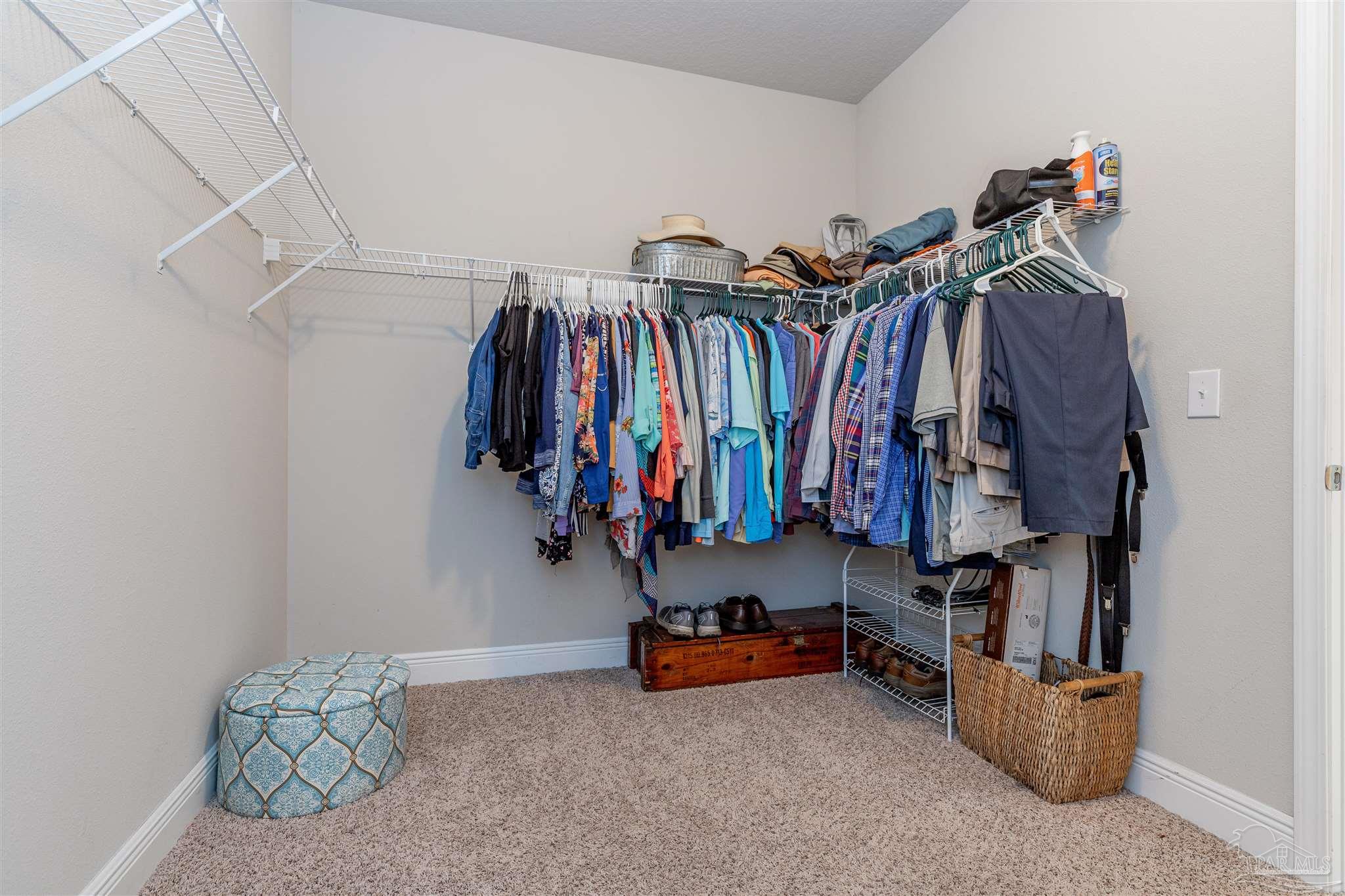 7997 Woodbrook Road Pensacola, FL 32526 - Photo 28 of 35 a view of walk in closet with clothes and shoes
