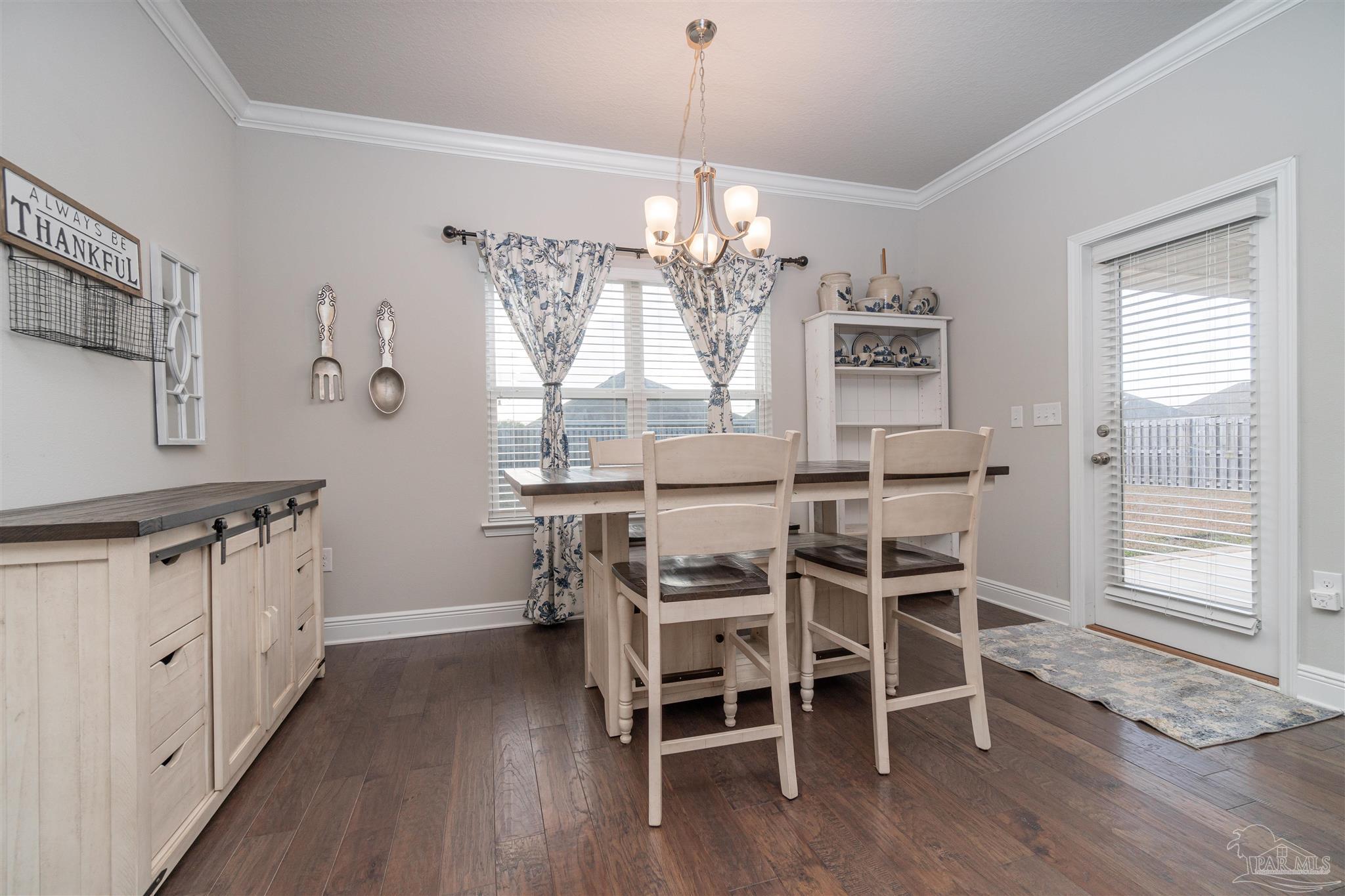 7997 Woodbrook Road Pensacola, FL 32526 - Photo 33 of 35 a dining room with wooden floors and chandelier
