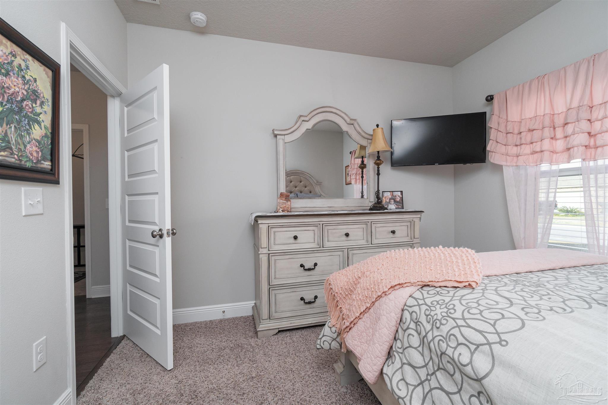 7997 Woodbrook Road Pensacola, FL 32526 - Photo 6 of 35 a bedroom with a bed and a flat screen tv