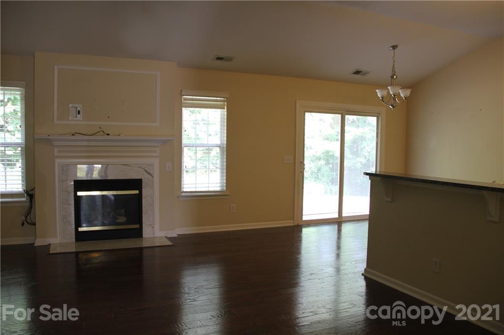 11233 Dickie Ross Road Charlotte, NC 28277 - Photo 4 of 26 a view of an empty room with wooden floor and a window