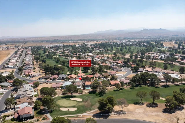 an aerial view of residential houses with outdoor space and trees