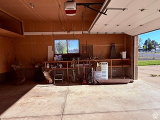588 North 4500 West West Point, UT 84015 - Photo 41 of 61 Attached two-car garage featuring a window, built-in shelving, and exposed wood paneling