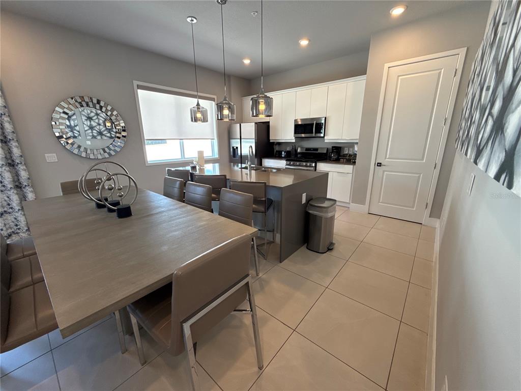 7740 Sandy Ridge Drive, Unit 120 Reunion, FL 34747 - Photo 6 of 36 a kitchen with stainless steel appliances kitchen island granite countertop a sink a stove and refrigerator