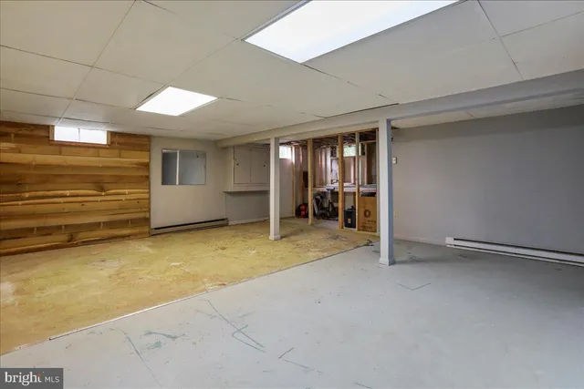 a view of an empty room with furniture and a window