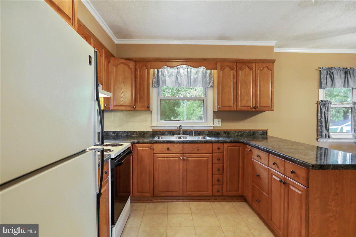 1956 Cattail Run Road Charles Town, WV 25414 - Photo 4 of 29 a kitchen with stainless steel appliances granite countertop a sink stove and refrigerator