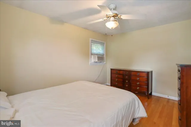 a bedroom with a bed chandelier and a window