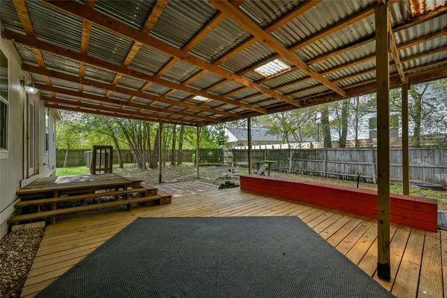 a backyard of a house with barbeque wooden table and chairs