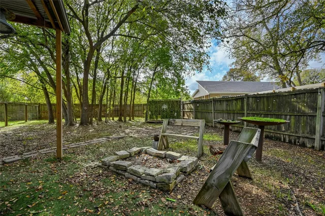 a wooden bench sitting in the middle of a backyard