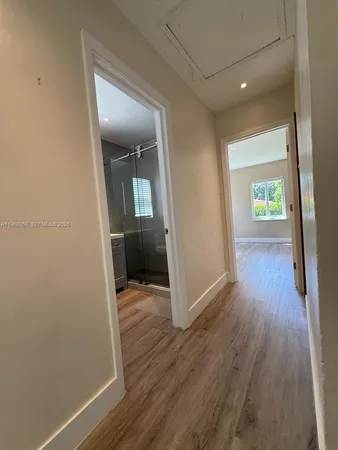 a view of an empty room with wooden floor and closet