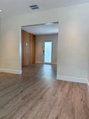 an entryway with wooden floor and a window