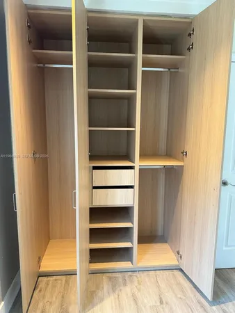 a view of walk in closet with empty racks