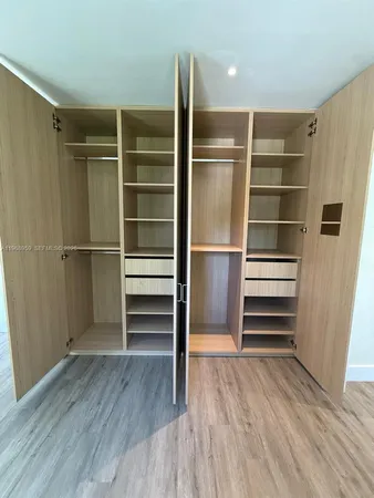 a view of walk in closet with empty racks