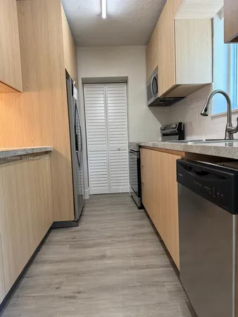 a view of a refrigerator in kitchen and a wooden floor