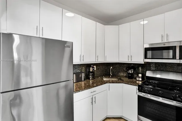 a kitchen with stainless steel appliances a refrigerator a stove a sink and cabinets