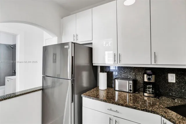 a kitchen with granite countertop a refrigerator a stove and a sink