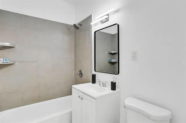 a bathroom with a toilet sink vanity and mirror