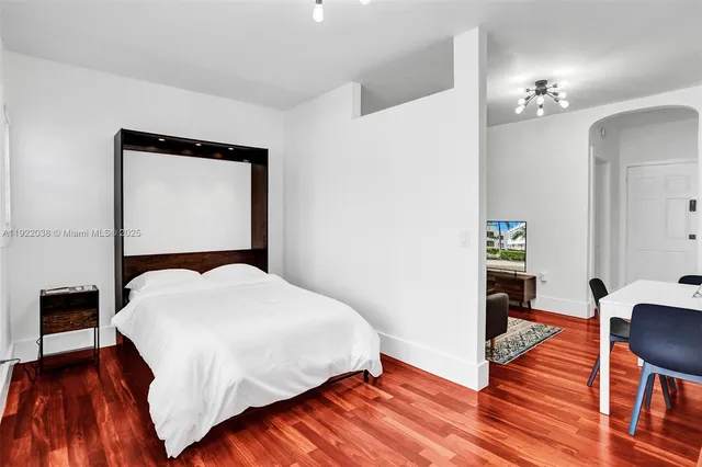 a bedroom with a bed and wooden floor