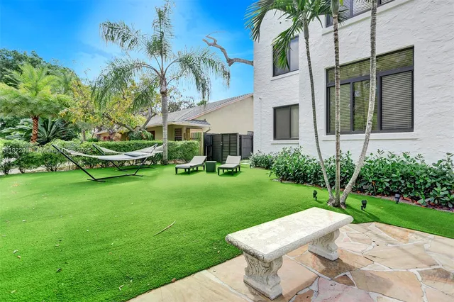 a view of a patio with table and chairs potted plants and palm trees