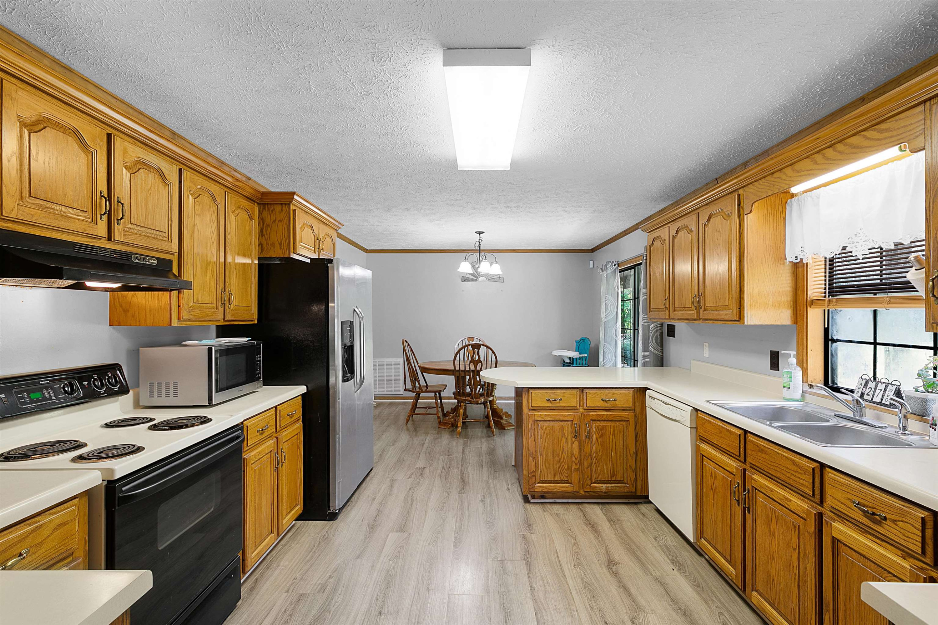 475 Liberty Claybrook Road Beech Bluff, TN 38313 - Photo 8 of 18 a kitchen with stainless steel appliances a stove top oven a sink dishwasher and wooden cabinets with wooden floor