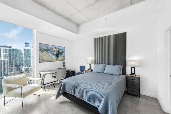 a bedroom with a large bed and a painting on the wall