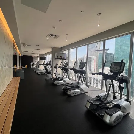a room with gym equipment and large windows