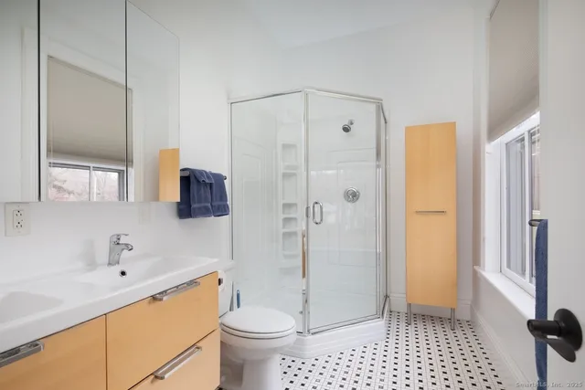 a bathroom with a sink a toilet and shower