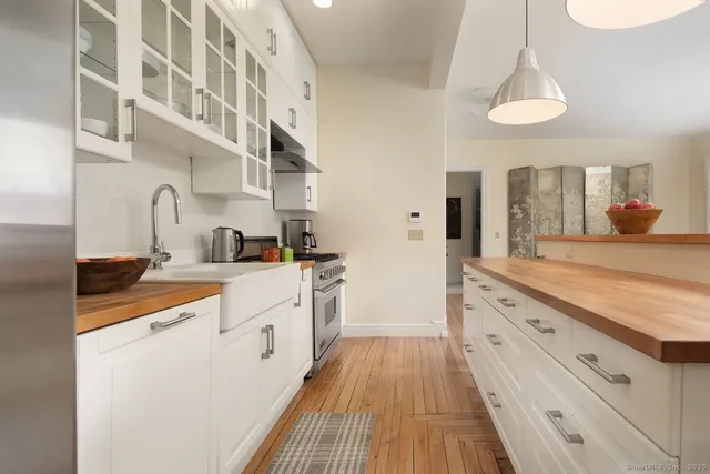 a kitchen with granite countertop a sink and dishwasher a stove top oven with wooden floor