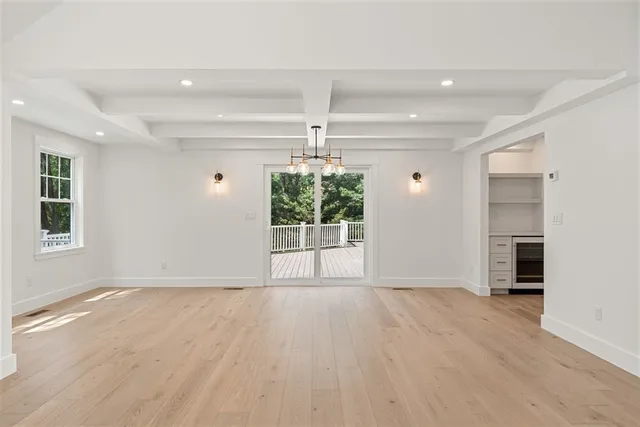 a large white kitchen with kitchen island a sink wooden floor and white cabinets