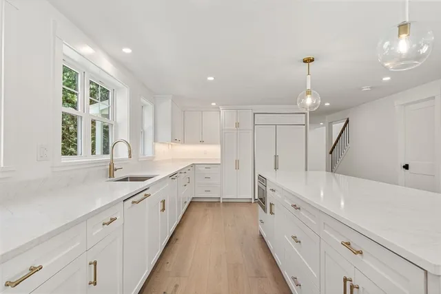 a large white kitchen with a large window
