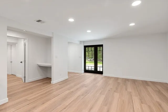 a view of an empty room with wooden floor