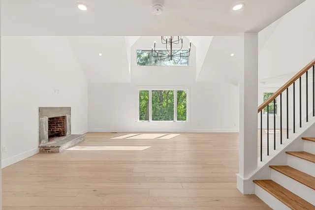 a view of an empty room with stairs and a window