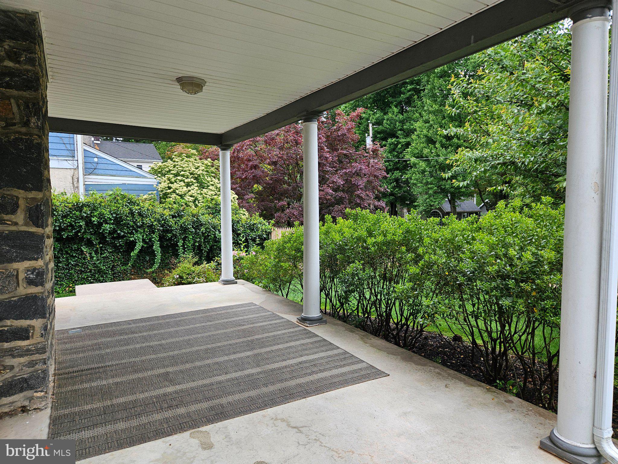 6 Arthur Road, Unit FRONT Rosemont, PA 19010 - Photo 2 of 24 Serene porch with lush greenery.