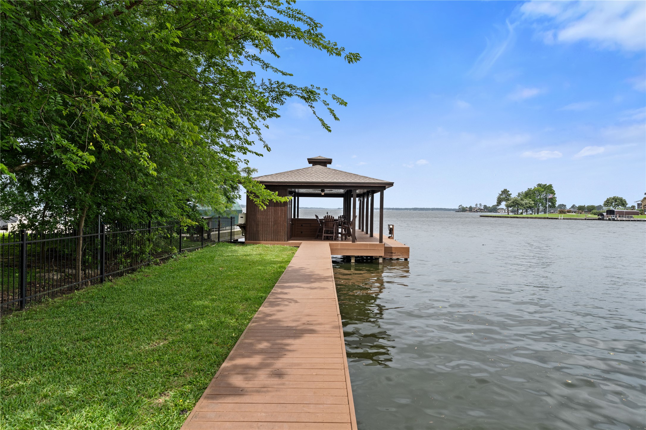 12349 Longmire Trace Conroe, TX 77304 - Photo 41 of 48 Private lakeside dock with covered pavilion and wide walkway, perfect for sunset views and waterfront living.