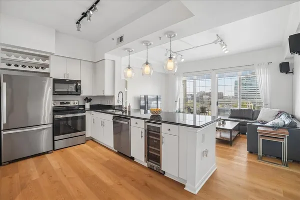 a kitchen with stainless steel appliances kitchen island granite countertop a stove and a refrigerator