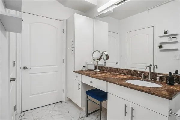 a bathroom with a granite countertop sink and a mirror