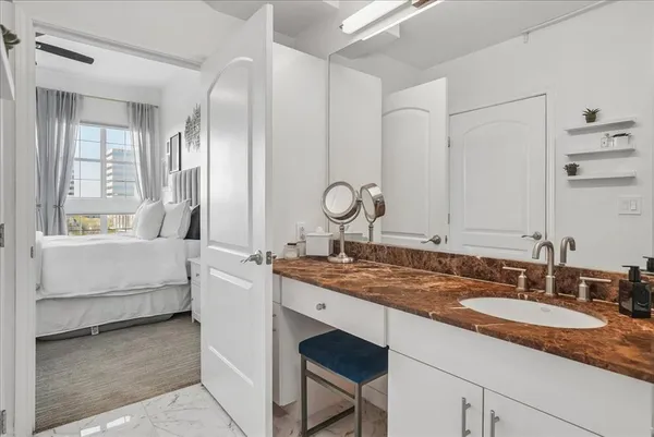 a bathroom with a sink double vanity granite tub shower and a mirror