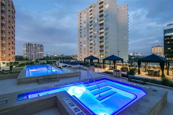 a swimming pool with outdoor seating and city view